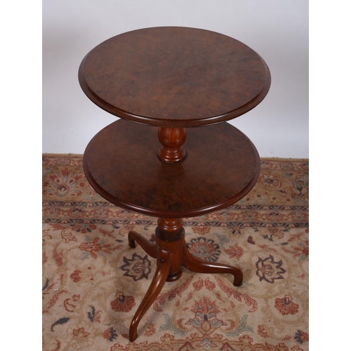 558 - A 19TH CENTURY WALNUT TWO TIER DUMBWAITER of circular outline each shelf joined by a baluster column... 