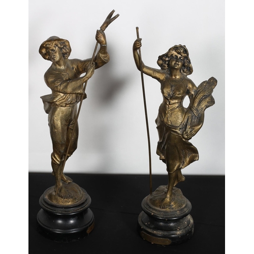 586 - A PAIR OF GILT SPELTER FIGURES modelled as a male and female each shown standing on an ebonised base... 