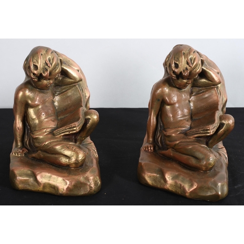 587 - A PAIR OF GILT PLASTER BOOKENDS each modelled as a young child shown reclining reading a book 
15cm ... 