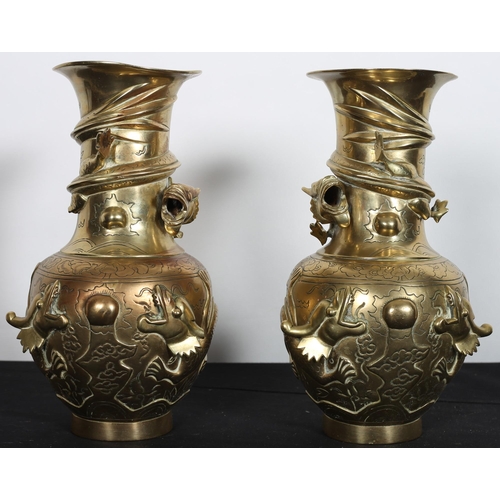 588 - A PAIR OF 19TH CENTURY BRASS VASES each of baluster form overlaid with dragons on a circular foot wi... 