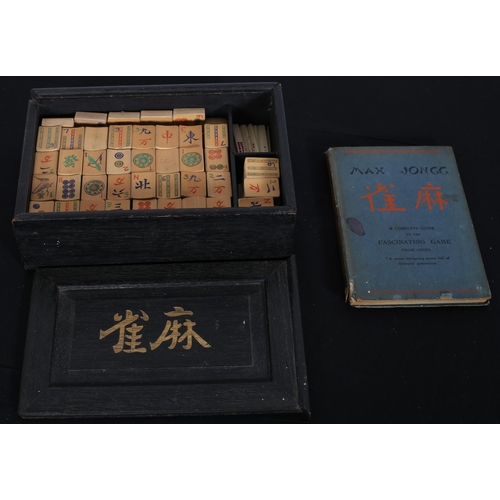 615 - A CHINESE A MAHJONG GAME in ebonised and gilt case with rules book and instructions with bone and ba... 