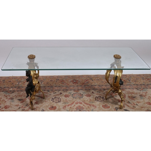 714 - A CONTINENTAL GILT BRASS AND GLAZED COFFEE TABLE the rectangular glazed top raised on foliate suppor... 