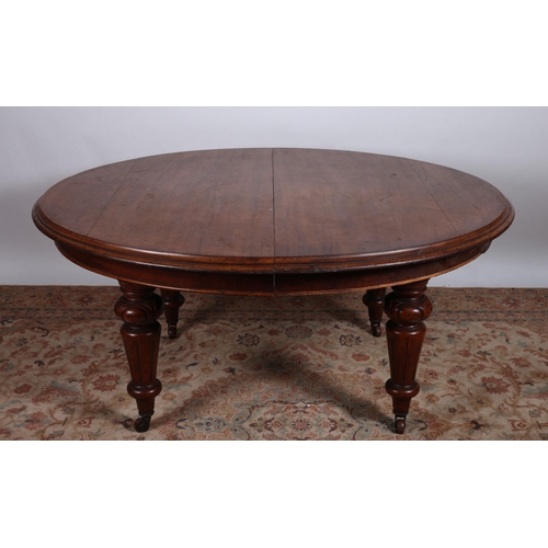 720 - A 19TH CENTURY MAHOGANY TELESCOPIC DINING TABLE of oval outline the shaped top with one loose leaf r... 