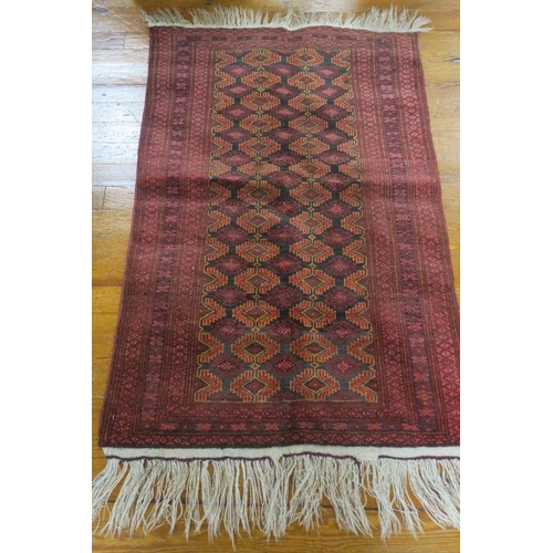 739 - AN ORIENTAL WOOL RUG the wine ground with central panel filled with serrated panels within a conform... 