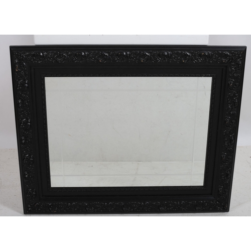 759 - AN EBONISED FRAME MIRROR THE RECTANGULAR PLATE with a foliate decorate frame
68 cm (h) x 82 cm (w)