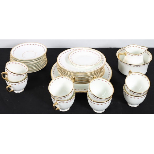 121 - A THIRTY SIX PIECE VINTAGE CHINA TEASET the white ground with gilt border and pink floral decoration... 