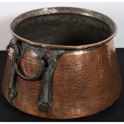 124 - A COPPER POT of circular spreading form with steel carrying handles 
22cm (h) x 42cm (d)