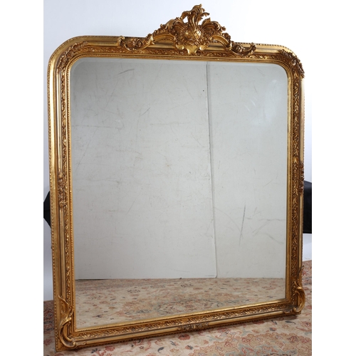 128 - A CONTINENTAL GILT FRAME MIRROR the rectangular bevelled glass plate within a foliate and flowerhead... 