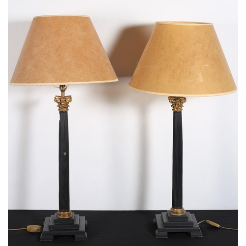 132 - A PAIR OF COMPOSITION BLACK PAINTED AND PARCEL GILT CORINTHIAN COLUMN TABLE LAMPS each with a reeded... 