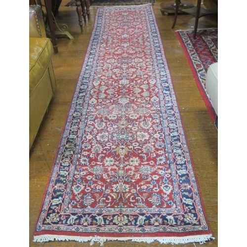 542 - A KESHAN WOOL RUNNER the red and indigo ground with central panelled filled with stylised flowerhead... 