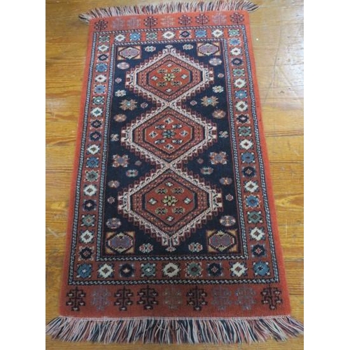 551 - AN ORIENTAL WOOL PRAYER RUG the indigo and wine ground with central diamond shaped panels filled wit... 