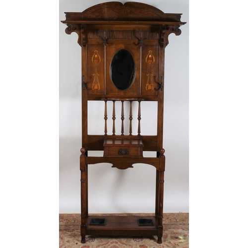 562 - AN ART NOUVEAU OAK INLAID HALL STAND the superstructure with moulded shelf above six hooks centred b... 