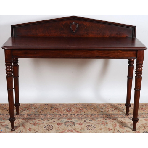 566 - A 19TH CENTURY MAHOGANY SIDE TABLE of rectangular outline the moulded back centred by a carved shiel... 