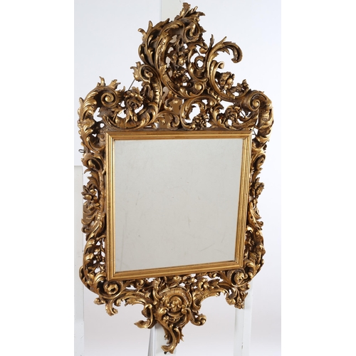 567 - A CONTINETNAL GILT FRAME MIRROR the rectangular plate within a pierced foliate and flowerhead frame ... 