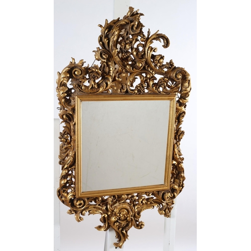 568 - A CONTINETNAL GILT FRAME MIRROR the rectangular plate within a pierced foliate and flowerhead frame ... 