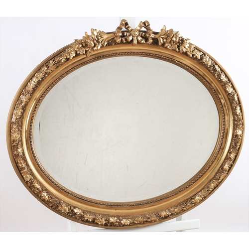 569 - A CONTINENTAL GILT FRAME MIRROR the oval bevelled glass plate within a beadwork and oak leaf decorat... 