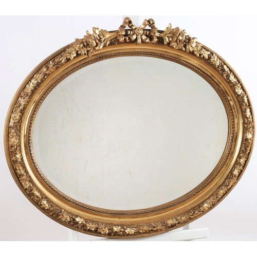 570 - A CONTINENTAL GILT FRAME MIRROR the oval bevelled glass plate within a beadwork and oak leaf decorat... 