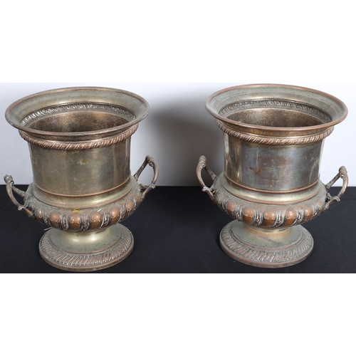 629 - A PAIR OF PLATE ON COPPER WINE COOLERS each of urn form with foliate cast handles raised on a circul... 