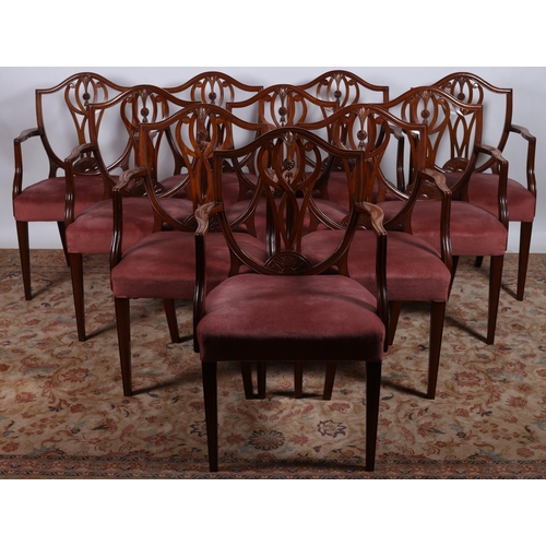 673 - A SET OF TWELVE HEPPLEWHITE DESIGN MAHOGANY ELBOW CHAIRS each with a shield shaped back and pierced ... 