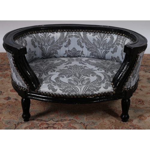 678 - A CONTINENTAL EBONISED AND UPHOLSTERED DOG / CAT BED of demi lune outline with upholstered back and ... 