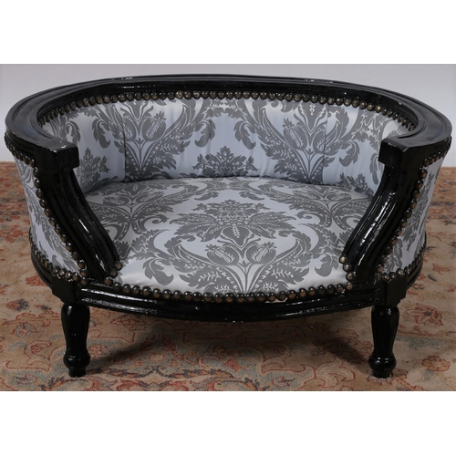 679 - A CONTINENTAL EBONISED AND UPHOLSTERED DOG / CAT BED of demi lune outline with upholstered back and ... 