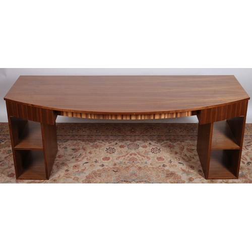 692 - A VINTAGE TEAK DESK of rectangular bowed outline the shaped top above two frieze drawers raised on t... 