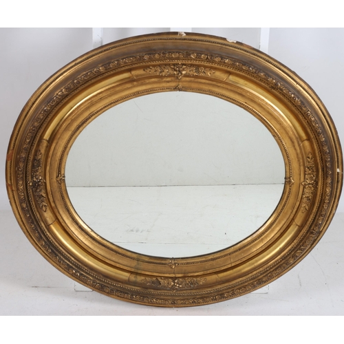 744 - A CONTINENTAL GILT FRAME MIRROR the oval plate within a foliate, flowerhead and beadwork decorated f... 