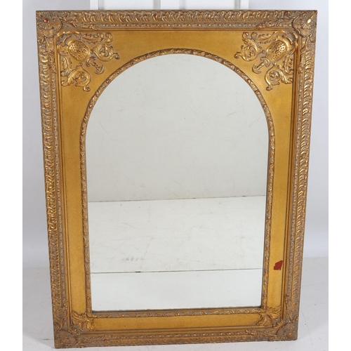 745 - A CONTINENTAL GILT FRAME MIRROR the rectangular arched plate within a moulded frame with C-scroll an... 