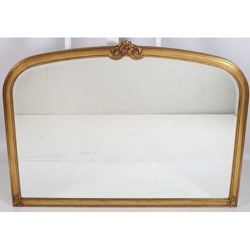 753 - A CONTINENTAL GILT FRAME OVERMANTLE MIRROR the rectangular arched bevelled glass plate within a moul... 