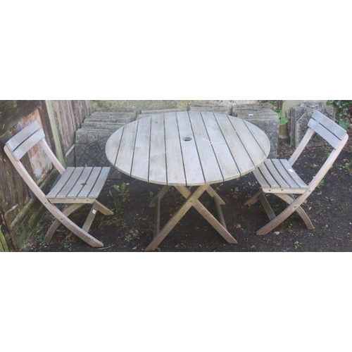 839 - A THREE PIECE TEAK PATIO SUITE comprising a pair of folding chairs a circular table on an X-shaped f... 