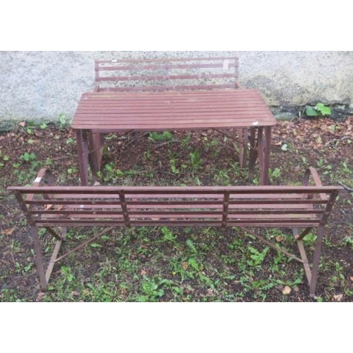 843 - A THREE PIECE WROUGHT IRON GARDEN SUITE comprising a three seater bench with slatted back and seat a... 