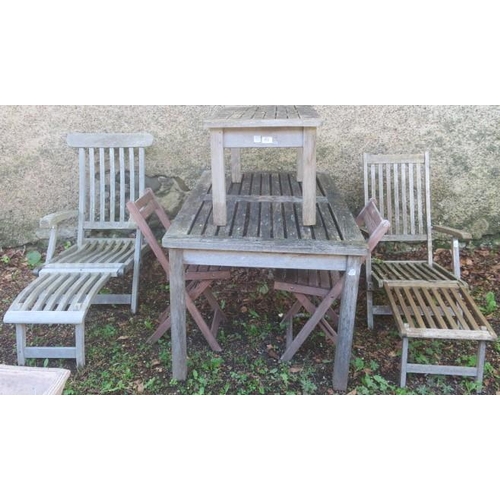 853 - A SIX PIECE TEAK PATIO SUITE comprising a pair of reclining loungers, a pair of folding chairs, a te... 