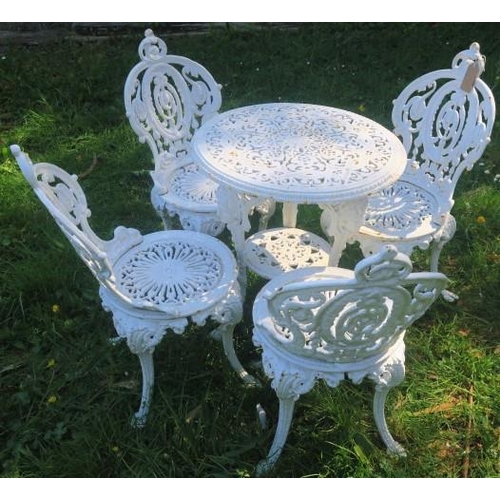 865 - A FIVE PIECE COALBROOKEDALE DESIGN CAST IRON PATIO SUITE comprising four chairs each with an oval pi... 