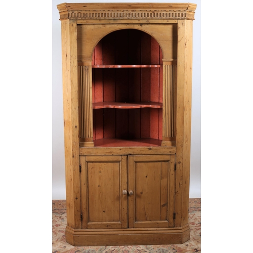 881 - A VINTAGE PINE CORNER CABINET of architectural outline the dentil moulded cornice above three open s... 