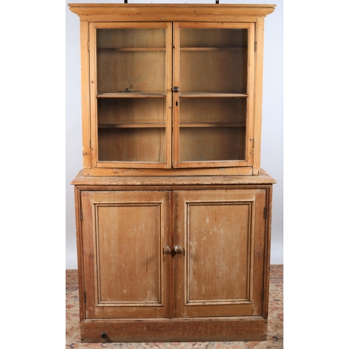 917 - A VICTORIAN PINE DRESSER of rectangular outline the moulded cornice above a pair of glazed doors con... 