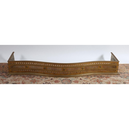 725 - A 19TH CENTURY BRASS FENDER of serpentine outline the pierced and beadwork frieze on a stepped base
... 