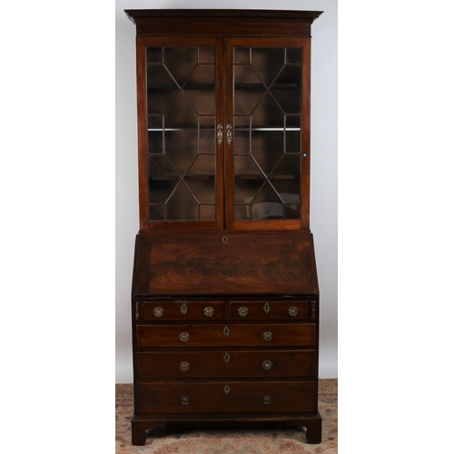 57 - A GEORGIAN MAHOGANY BUREAU BOOKCASE with associate top the dentil moulded cornice above a pair of as... 