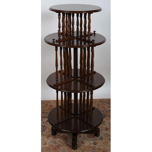 72 - A CONTINENTAL STAINED BEECHWOOD FOUR TIER REVOLVING BOOKSTAND each circular moulded shelf joined by ... 