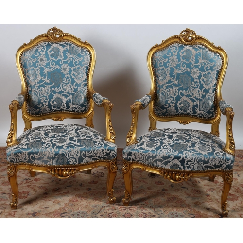 627 - A PAIR OF CONTINENTAL GILTWOOD AND UPHOLSTERED ARMCHAIRS each with a foliate carved top rail with up... 