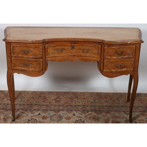 237 - A CONTINENTAL LIMED OAK SIDE TABLE of serpentine outline the shaped crossbanded top above a frieze d... 