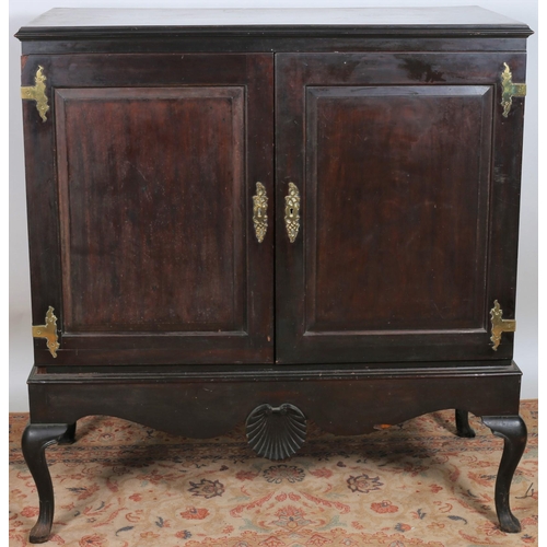 22 - AN IRISH GEORGIAN MAHOGANY AND BRASS BOUND CUPBOARD of rectangular outline the shaped top above a pa... 