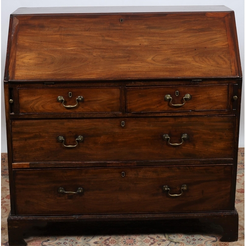 235 - A GEORGIAN MAHOGANY BUREAU the hinged writing slope containing pigeon holes and drawers above two sh... 