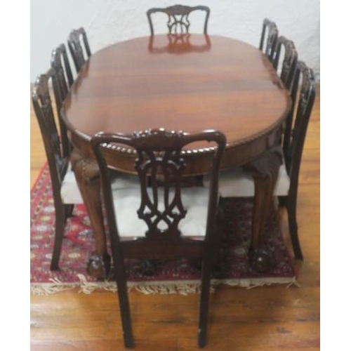 25 - A NINE PIECE CHIPPENDALE DESIGN MAHOGANY DINING ROOM SUITE comprising eight chairs each with a carve... 
