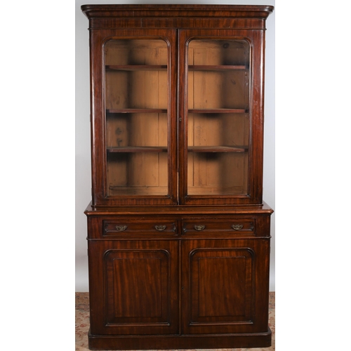 28 - A 19TH CENTURY TWO DOOR LIBRARY BOOKCASE the moulded cornice above a pair of glazed doors containing... 