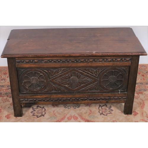 34 - A JACOBEAN DESIGN CARVED OAK COFFER of rectangular outline the hinged lid above a carved frieze on s... 