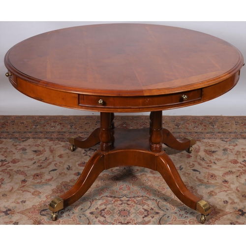 45 - A CHERRYWOOD POD TABLE of circular outline the shaped top with three frieze drawers raised on quadru... 