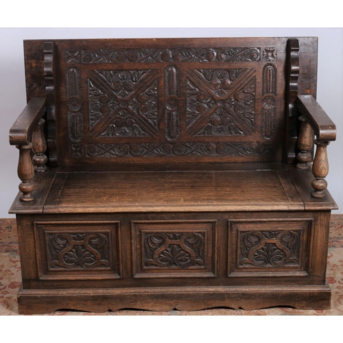 456 - A JACOBEAN DESIGN CARVED OAK MONK'S BENCH the rectangular hinged top with carved panels above a hing... 