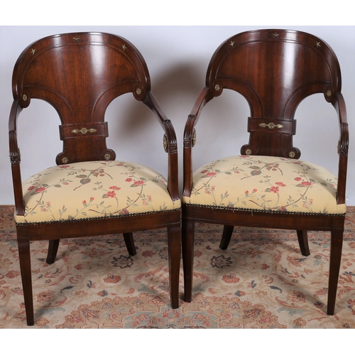 48 - A PAIR OF REGENCY DESIGN MAHOGANY AND BRASS MOUNTED ELBOW CHAIRS each with a curved back and upholst... 