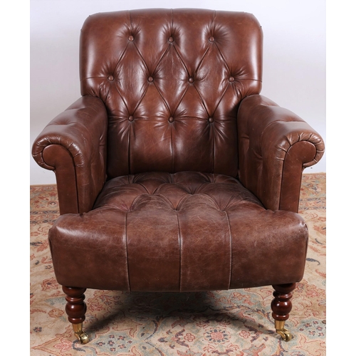 5 - A VINTAGE HIDE UPHOLSTERED LIBRARY ARMCHAIR with deep buttoned upholstered back and seat on turned l... 