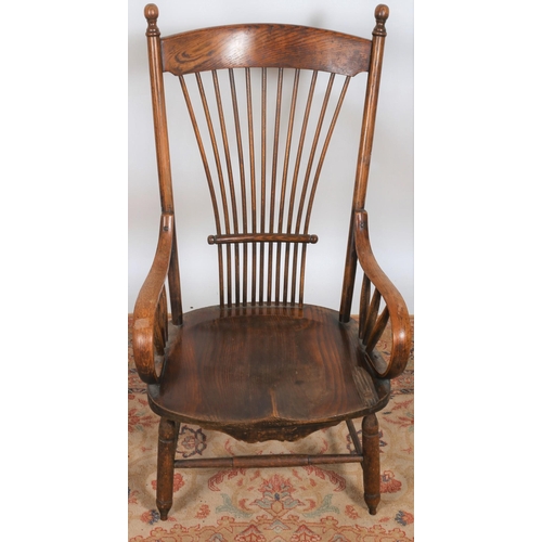 12 - A VINTAGE OAK ELBOW CHAIR the curved top rail with spindle splats and shaped seat with scroll arms o... 
